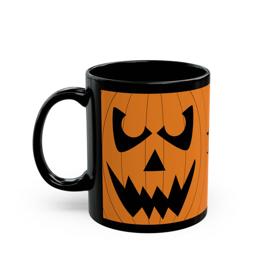 A black ceramic mug featuring a printed orange jack-o'-lantern face design on the side, shown against a plain white background.