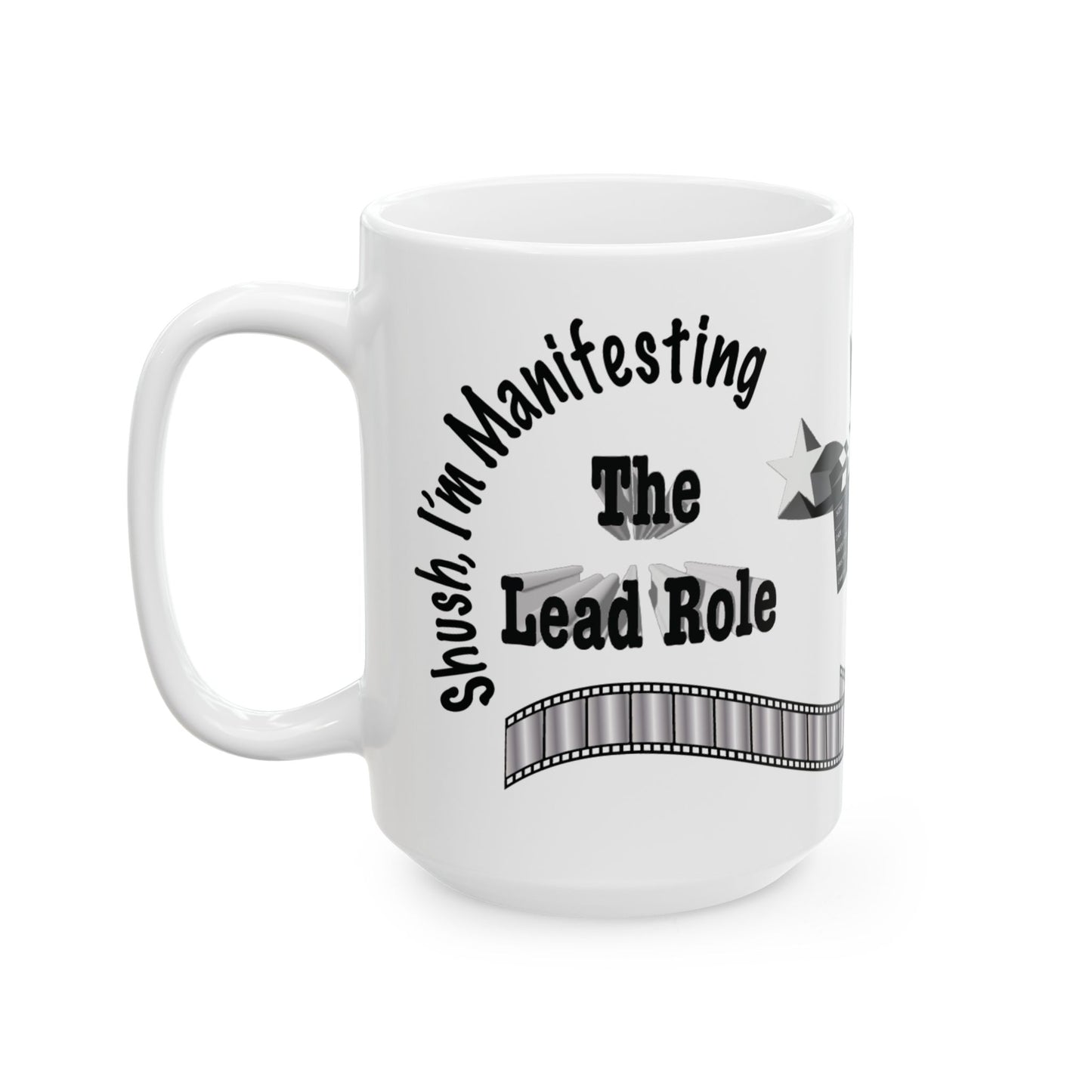 A white ceramic mug with a black printed graphic that reads 'Shush, I'm Manifesting The Lead Role' with a film strip design, shown on a plain white background.