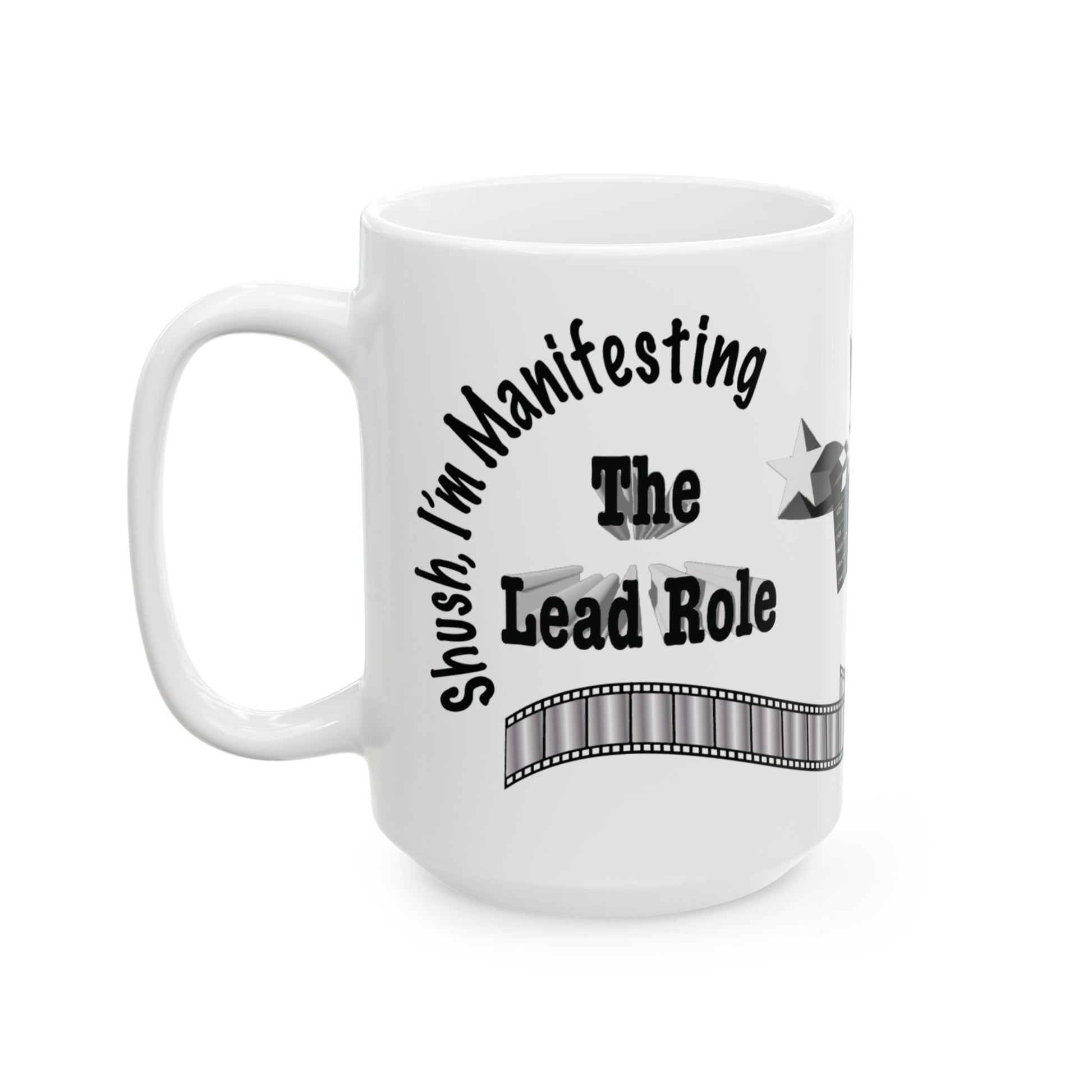 A white ceramic mug with a black printed graphic that reads 'Shush, I'm Manifesting The Lead Role' with a film strip design, shown on a plain white background.