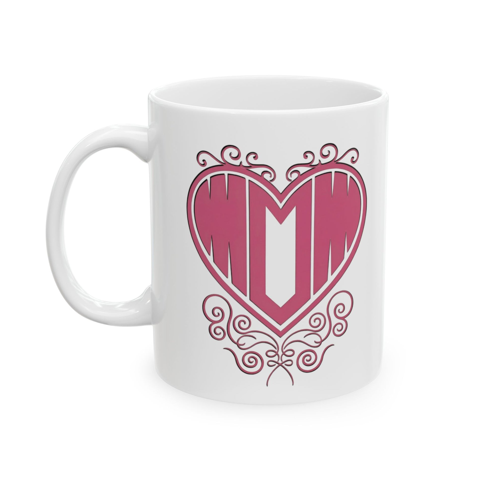 White ceramic mug with "Mom" printed in pink text inside a heart with decorative filigree, on a white background.