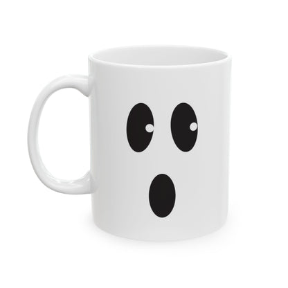 A white ceramic mug with a cartoon ghost face graphic on the front, set against a plain white background.