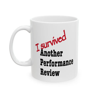 White ceramic "I Survived Another Performance Review" mug with bold sarcastic text, glossy finish funny office humor coffee cup for corporate survivors


