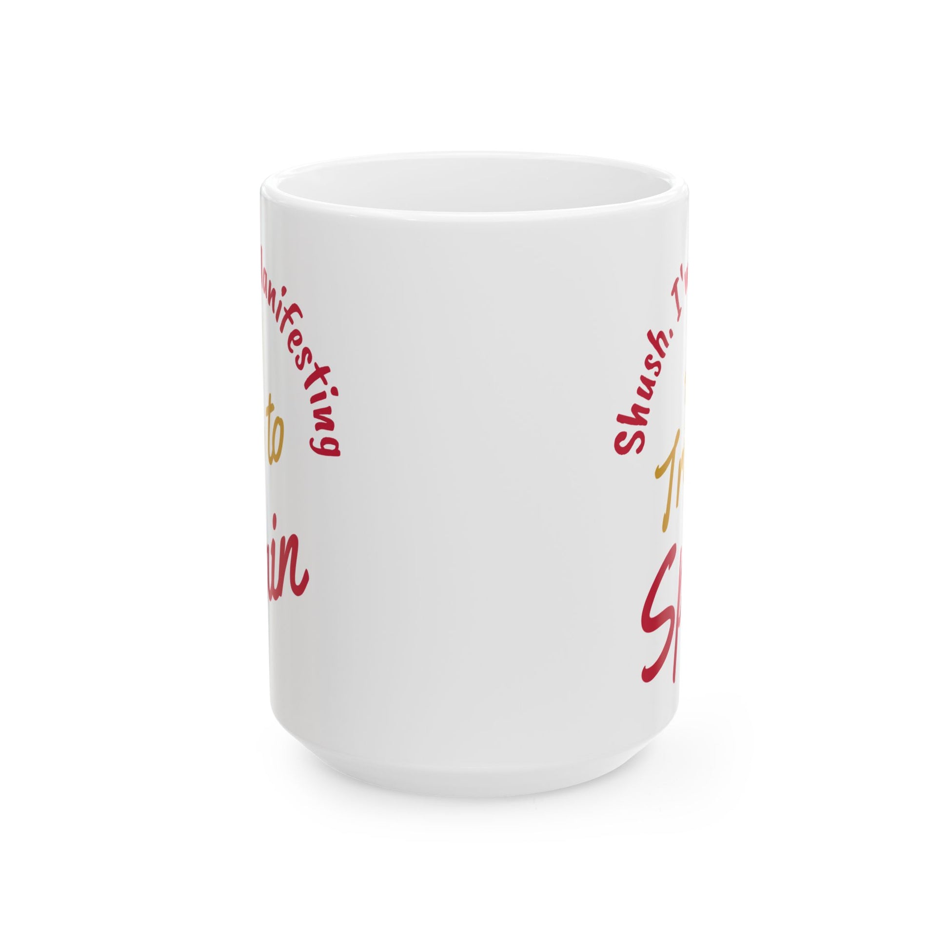 'Shush I'm Manifesting A Trip to Spain' 15oz ceramic mug front center view on white background.