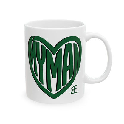 A white ceramic coffee mug featuring a green heart outline graphic with the word 'MYMAN' written inside in a stylized font, on a clean white background.