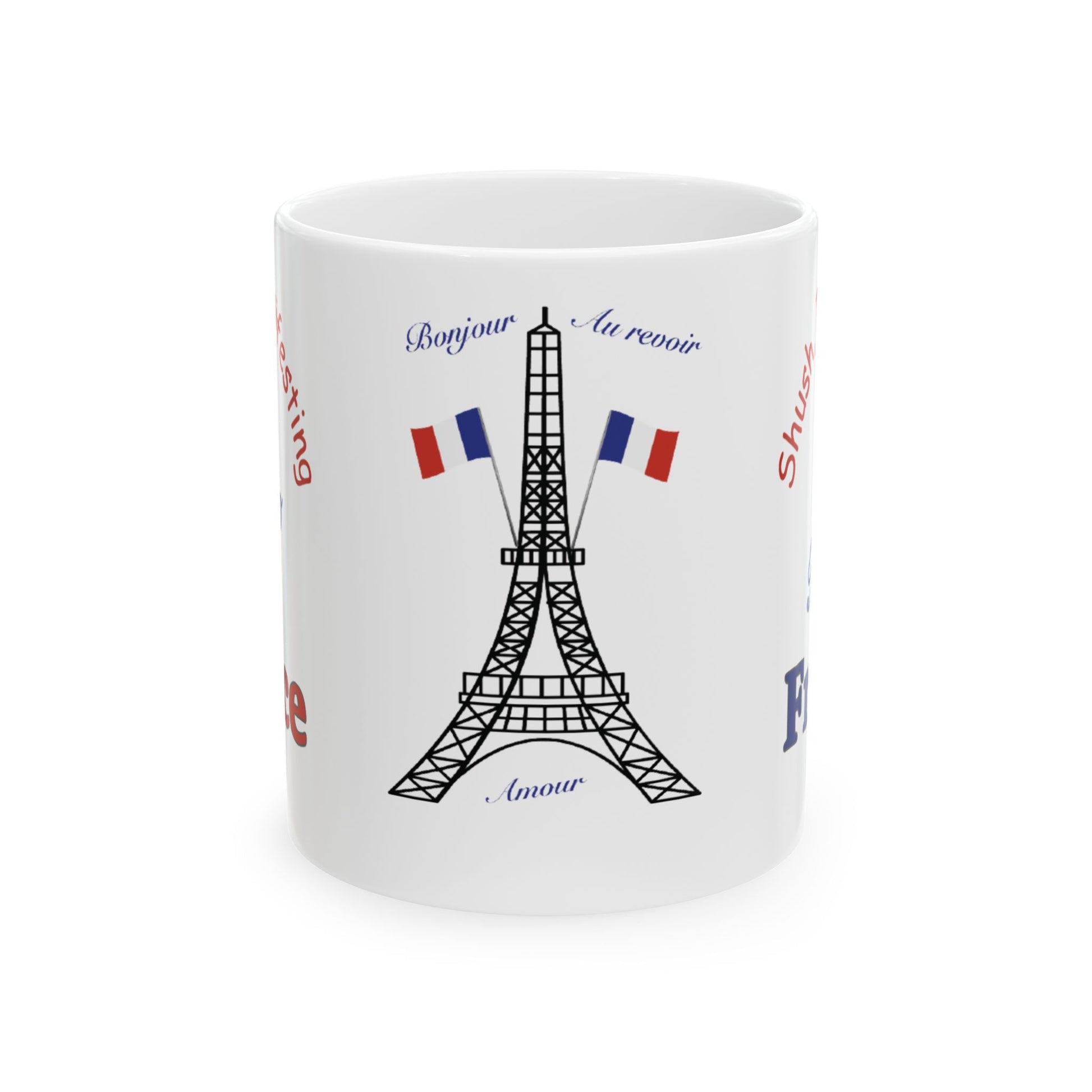 A white ceramic mug featuring a black line art illustration of the Eiffel Tower, flanked by two French flags, with decorative blue and red text around the design.