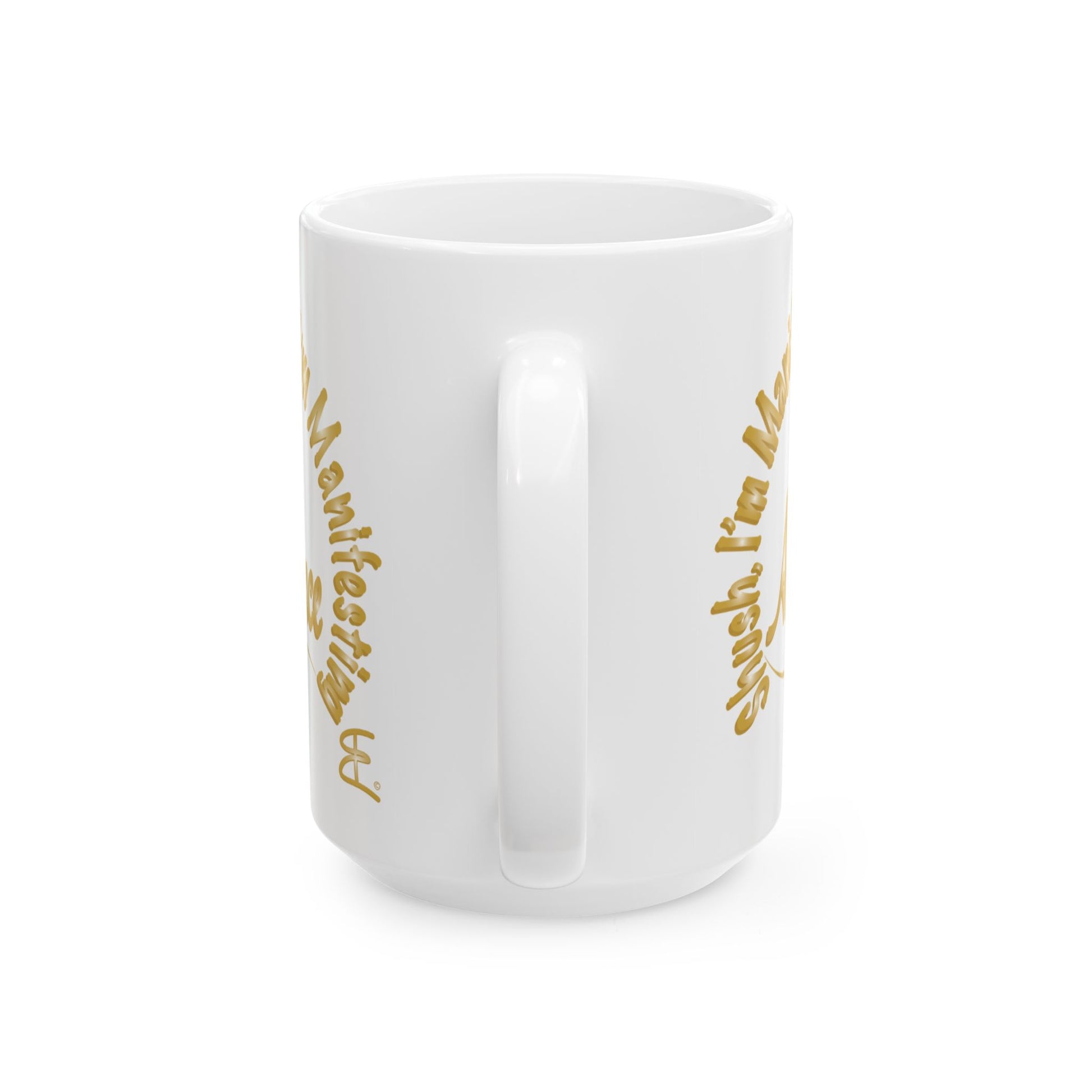 A white ceramic mug with a glossy finish, featuring gold script text printed on both sides, shown against a plain white background.