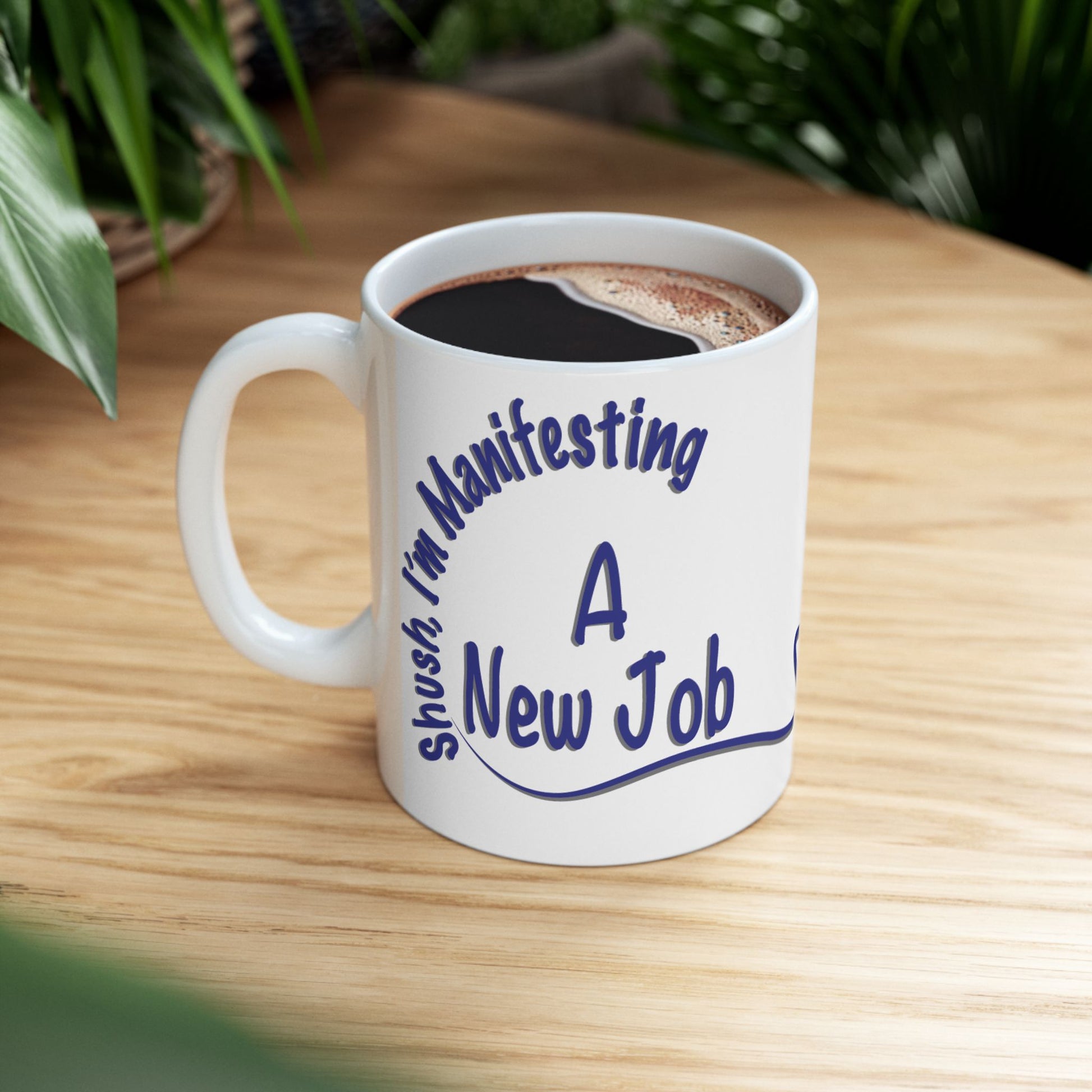 'Shush, I’m Manifesting A New Job' — ceramic mug lifestyle picture on wooden desk