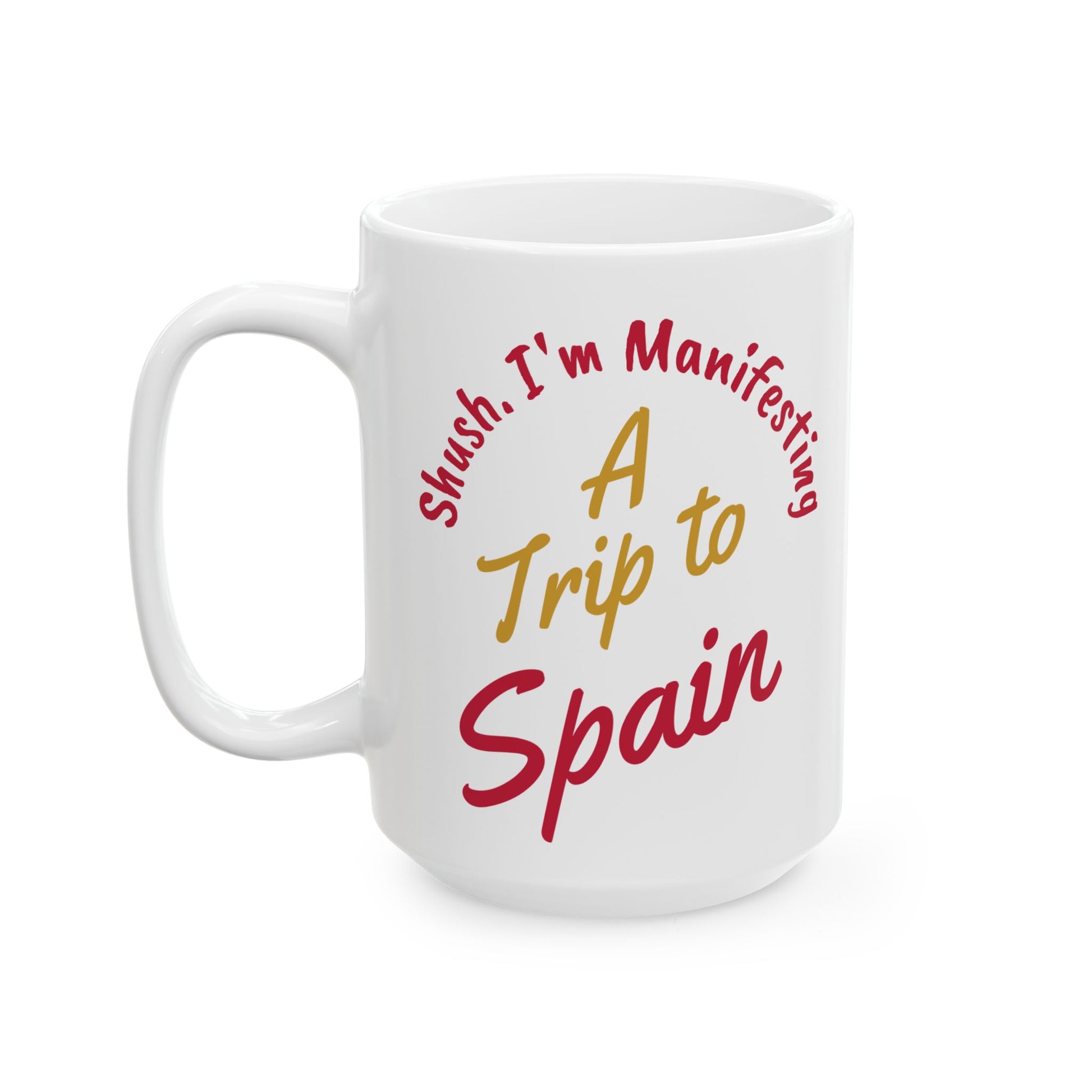 'Shush I'm Manifesting A Trip to Spain', 15oz ceramic mug left handle view on white background.