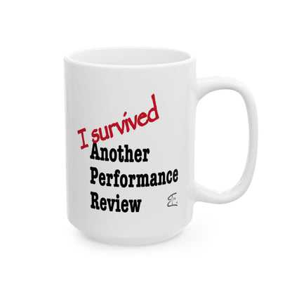 A white ceramic mug with the text 'I survived Another Performance Review' printed on it. 'I survived' is in red script, while 'Another Performance Review' is in black serif font.