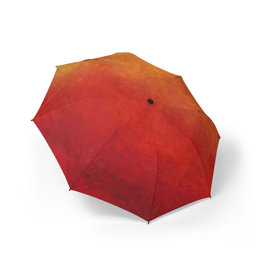Angled view of a Firelight Gradient-colored umbrella sitting on the ground of a white background.