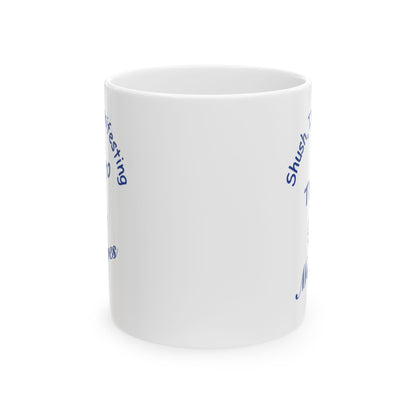 A white ceramic mug with blue text partially visible on the sides, shown against a plain white background.