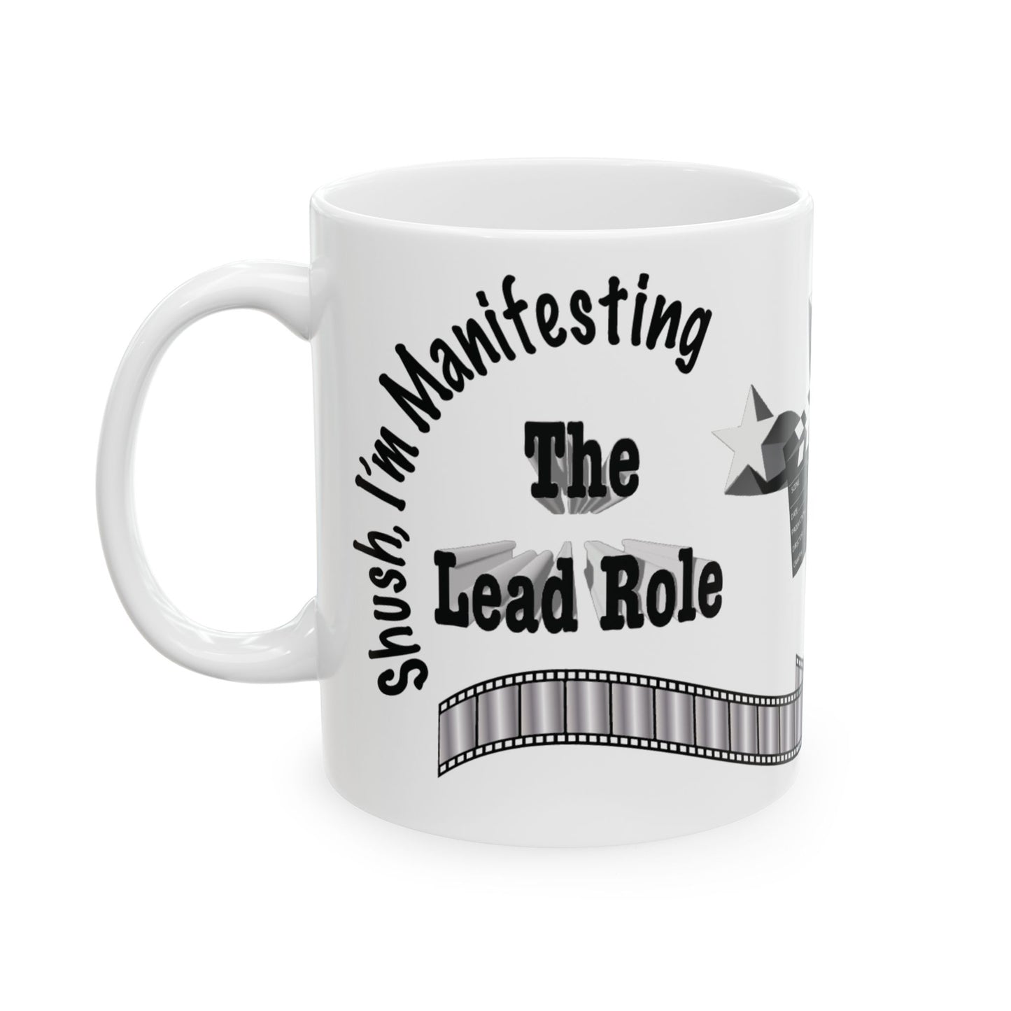 A white ceramic mug with a black printed graphic that reads 'Shush, I'm Manifesting The Lead Role' with a film strip design, shown on a plain white background.
