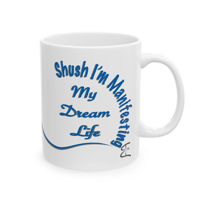 White ceramic mug with the text 'Shush, I'm Manifesting My Dream Life'

