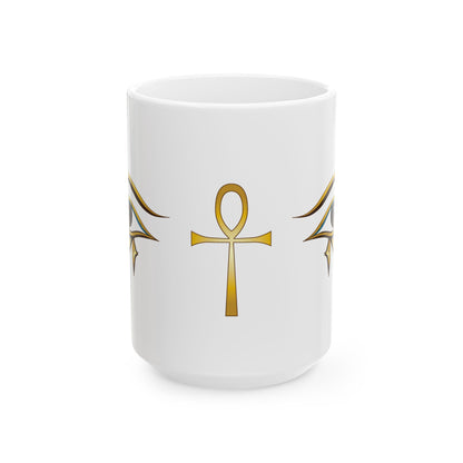 A white ceramic mug featuring a gold Egyptian ankh symbol printed on the front, flanked by matching gold wing-like motifs on either side, set against a plain white background.