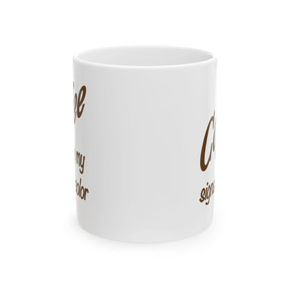 A white ceramic coffee mug with brown cursive text partially visible on the side, shown against a plain white background.