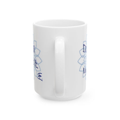 White ceramic mug, angled front view with light blue mandala artwork and partial blue text.