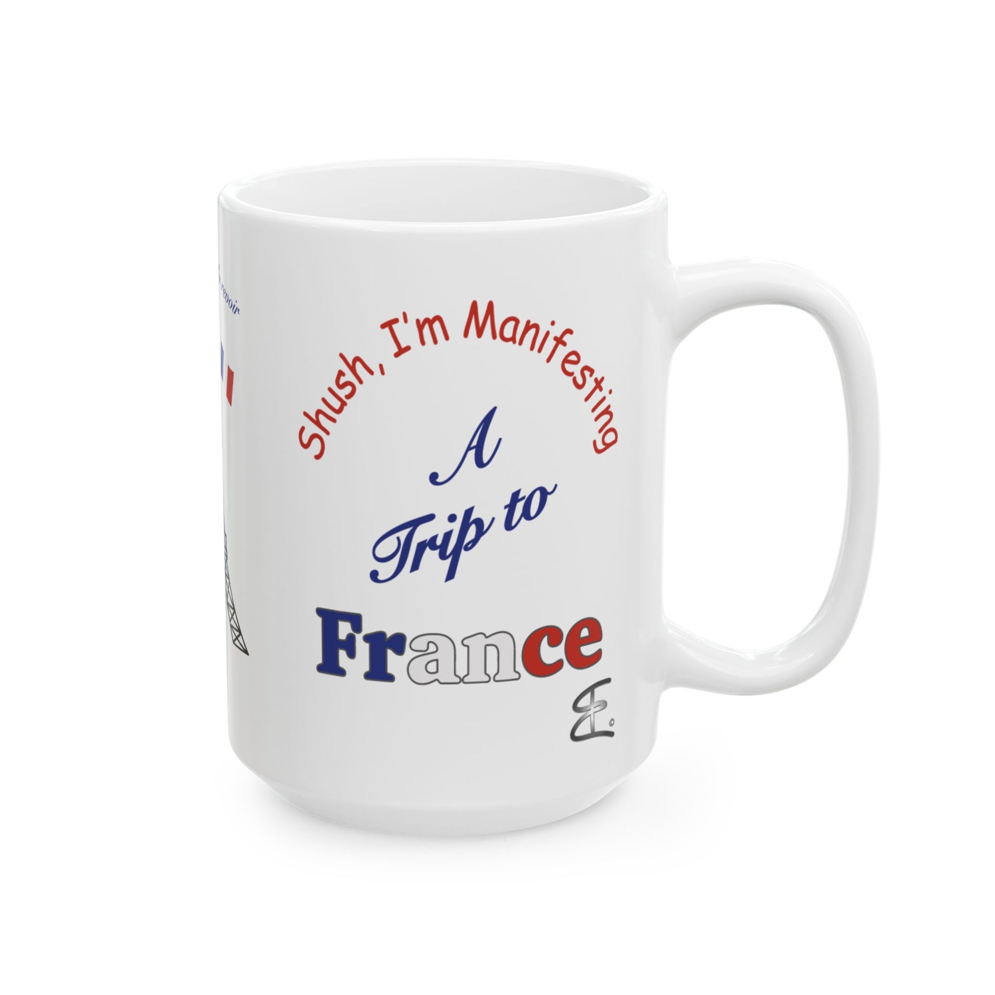 A white ceramic coffee mug with a humorous graphic that reads 'Shush, I'm Manifesting A Trip to France.'