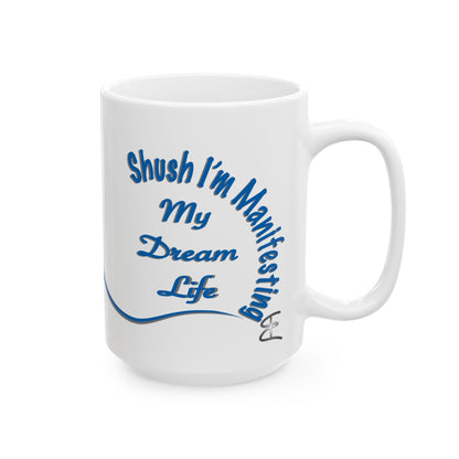 White ceramic mug with the text 'Shush, I'm Manifesting My Dream Life'

