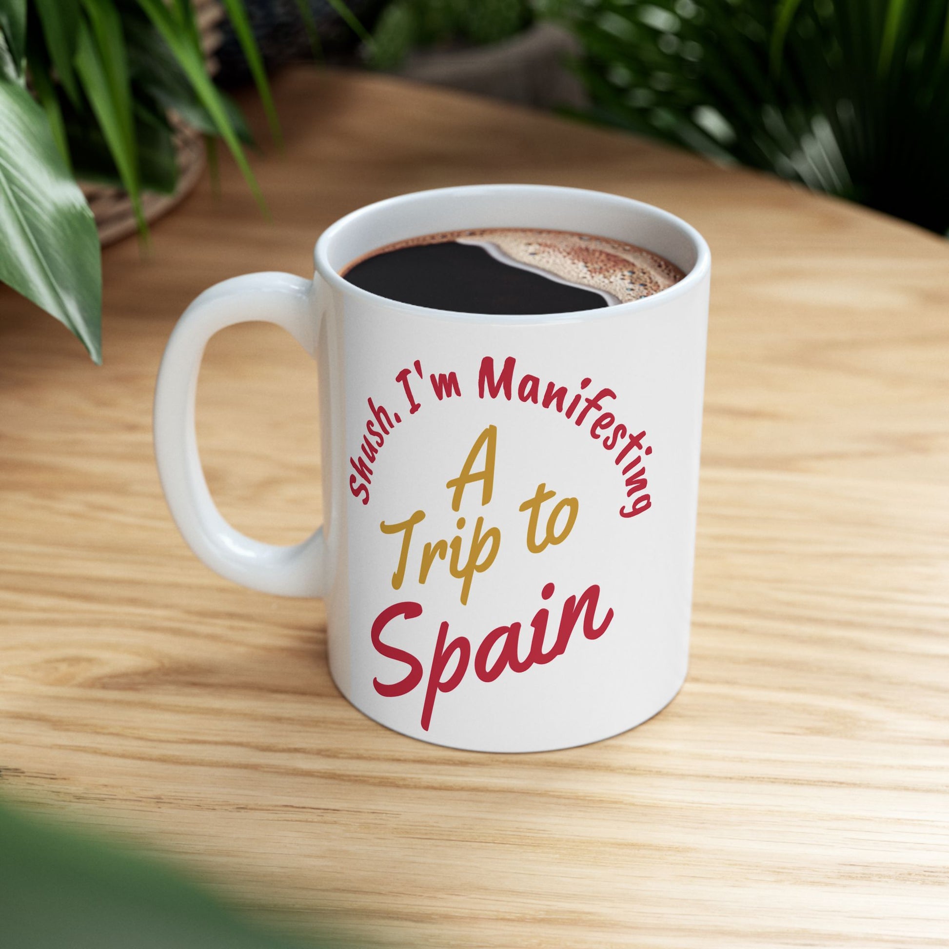 'Shush I'm Manifesting A Trip to Spain' Ceramic Mug Lifestyle picture on wooden desk