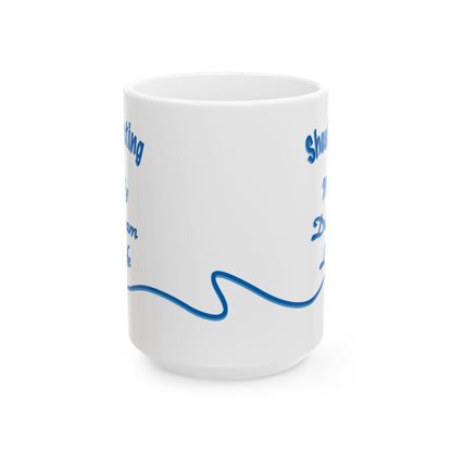 A white ceramic mug with blue printed text and a wavy line design, shown on a clean white background.