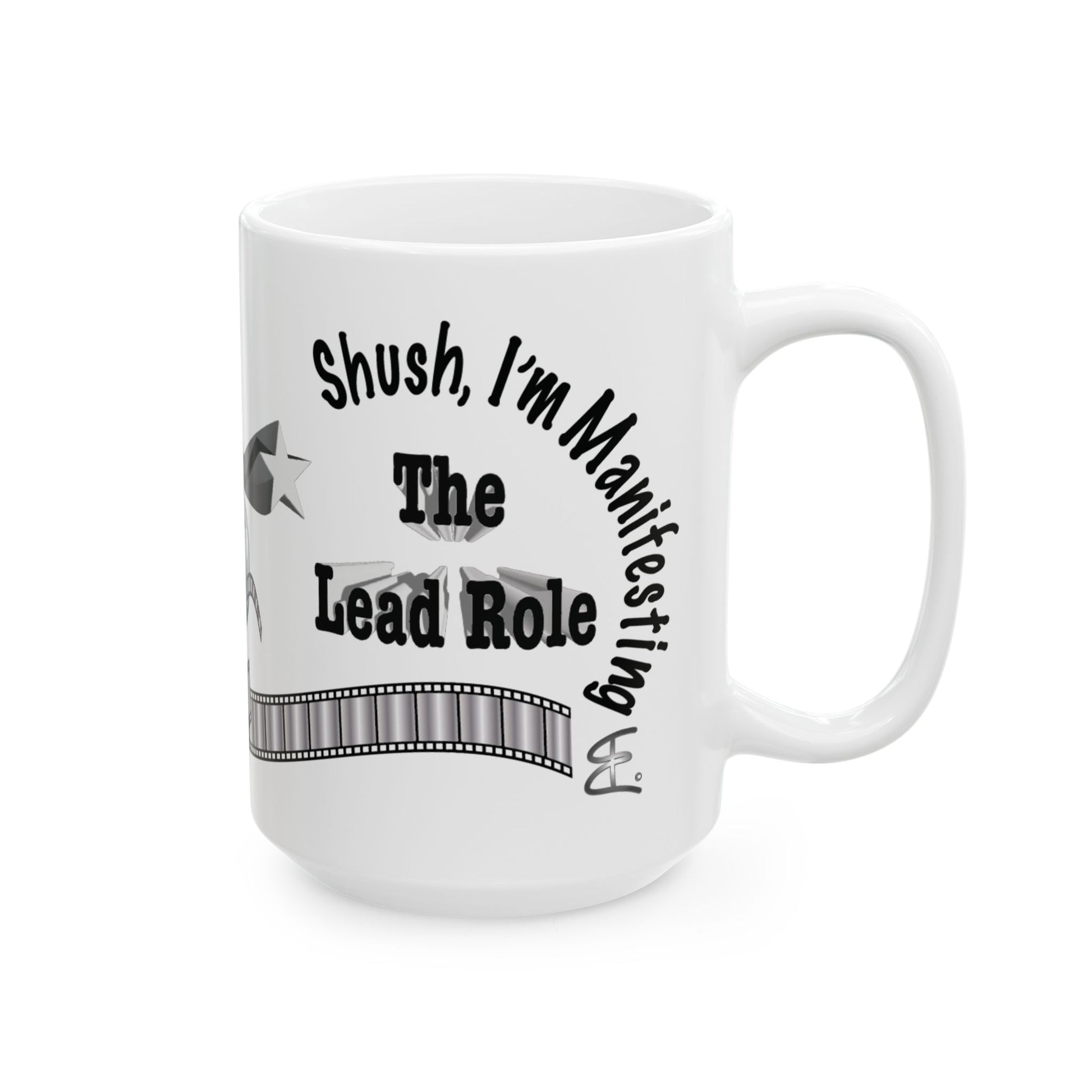 A white ceramic mug with a black printed graphic that reads 'Shush, I'm Manifesting The Lead Role' with a filmstrip design, shown on a plain white background.