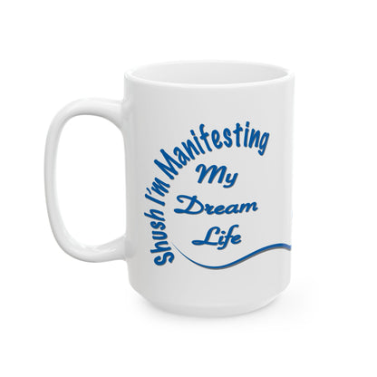 White ceramic mug with the text 'Shush, I'm Manifesting My Dream Life'


