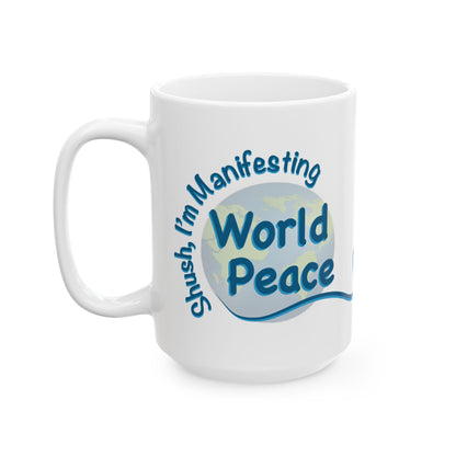 A white ceramic mug with a blue and light blue graphic design that reads 'Shush, I'm Manifesting World Peace' on a clean white background.