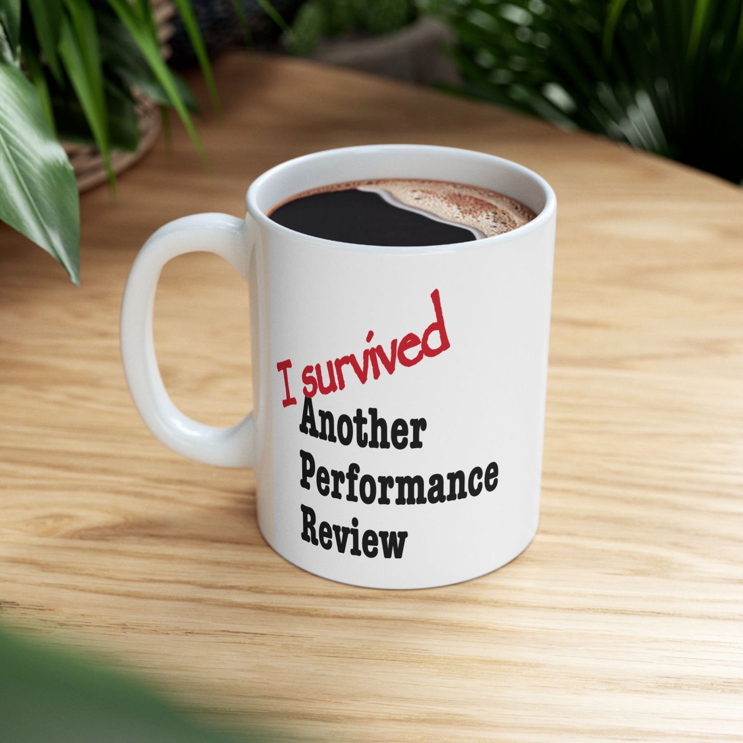 "I Survived Another Performance Review" mug displayed on plain background, relatable corporate sarcasm coffee cup for desks and home office
